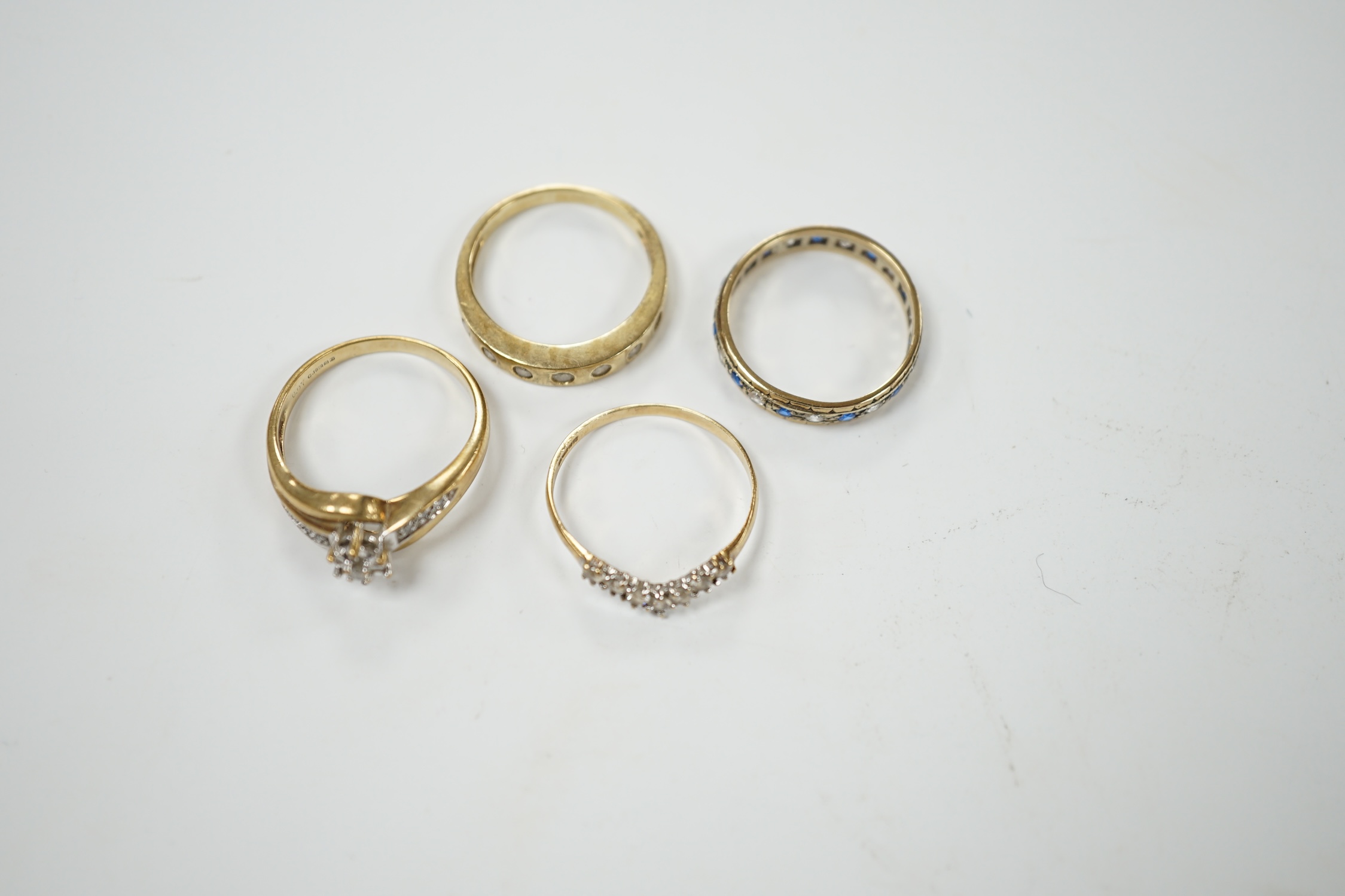 Two modern 9ct gold and diamond set rings and a 9ct gold, simulated diamond set chevron shaped ring and one other 9ct and paste set band, gross weight 9 grams. Condition - poor to fair